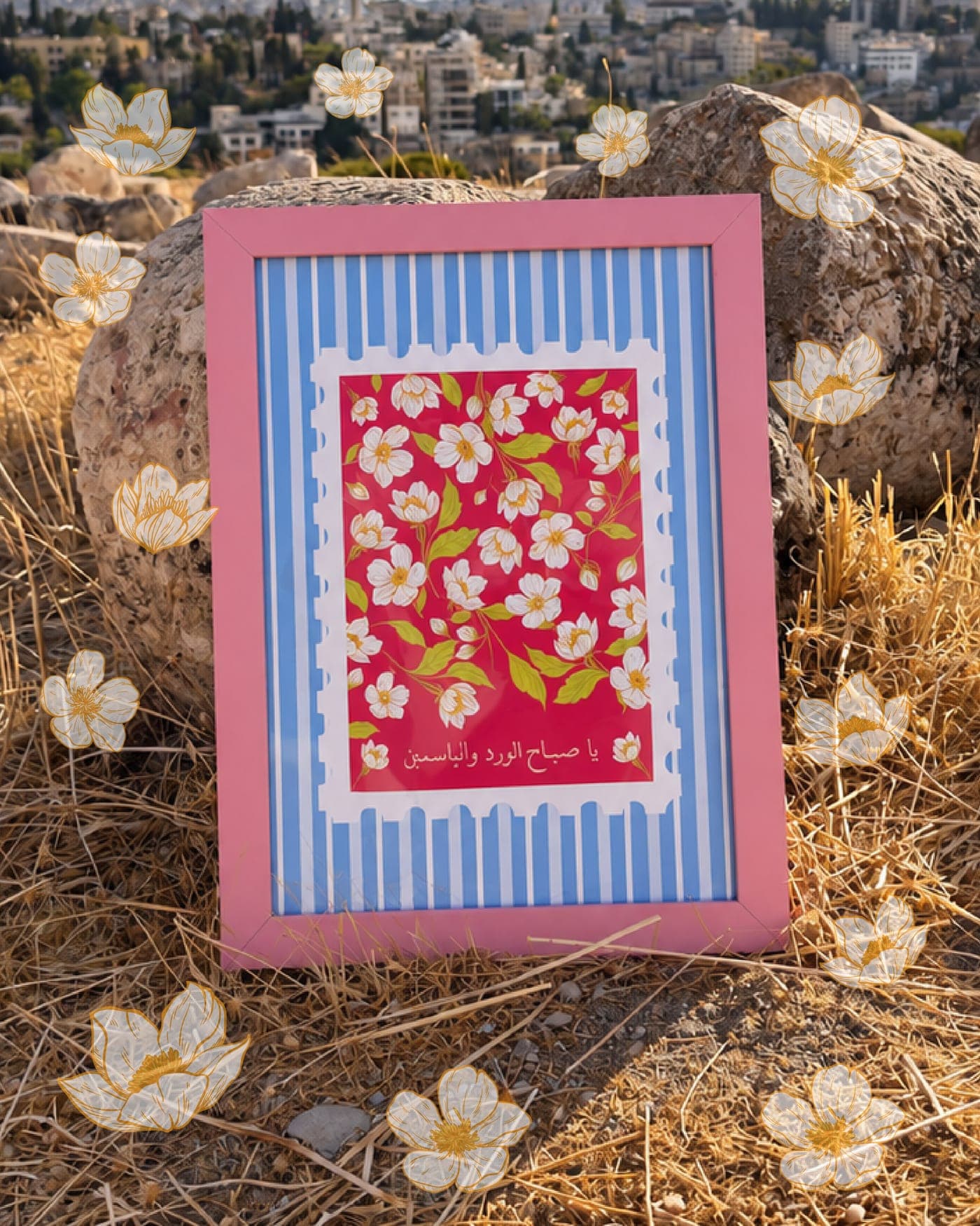 Jasmine print in a pink frame leaning on a rock among dry grass