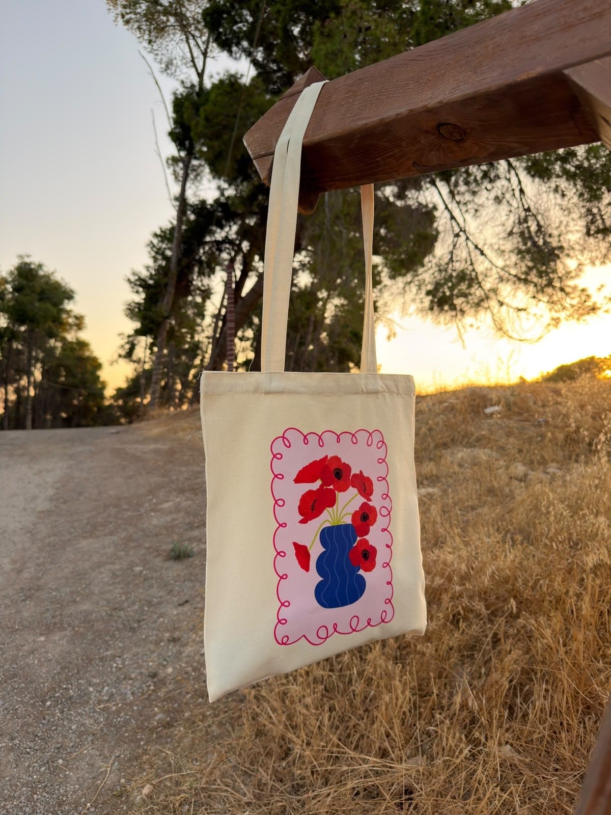 Dahnon canvas tote hanging from a wooden beam at sunset